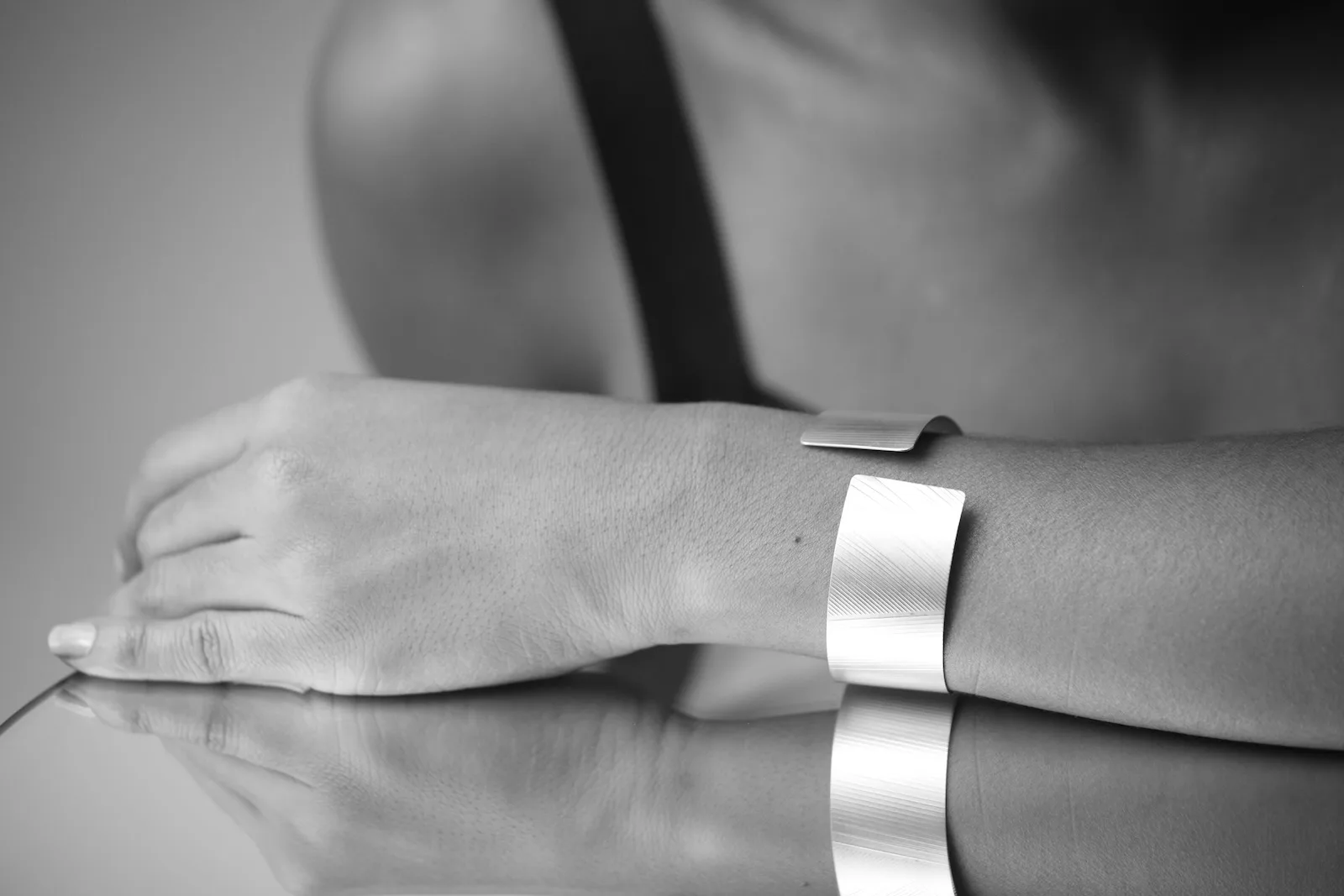 Close-up of wrist wearing a wide polished silver cuff