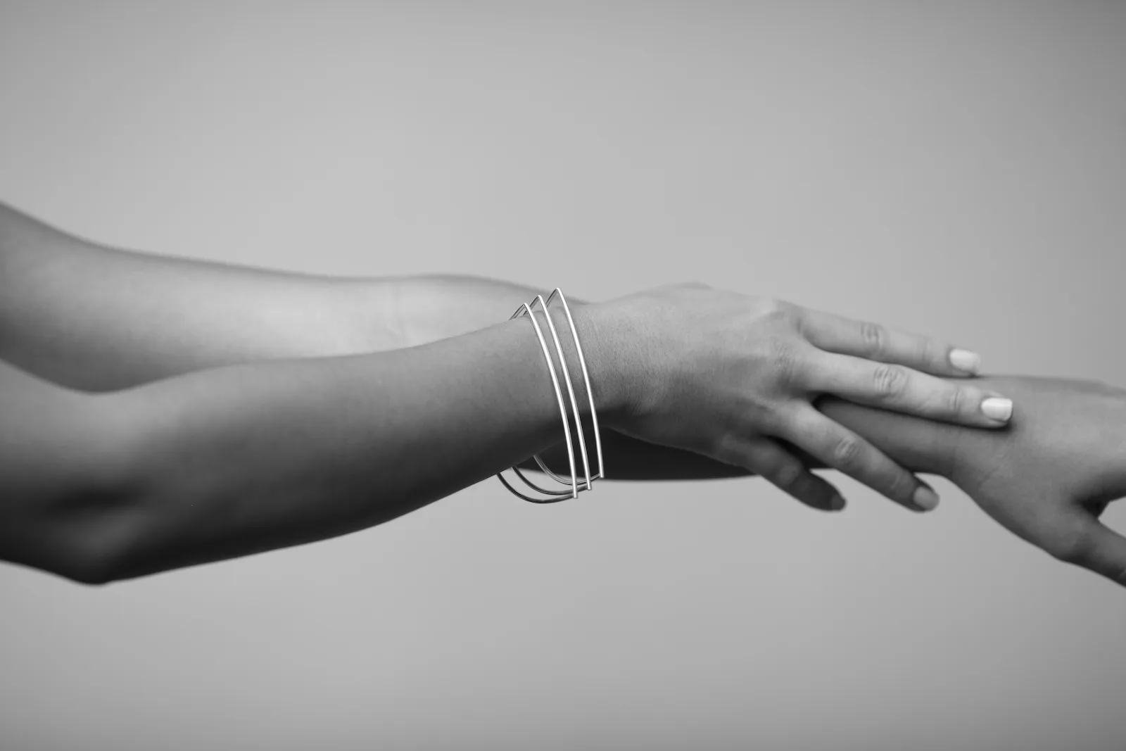 Wrist with several stacked thin silver bangles