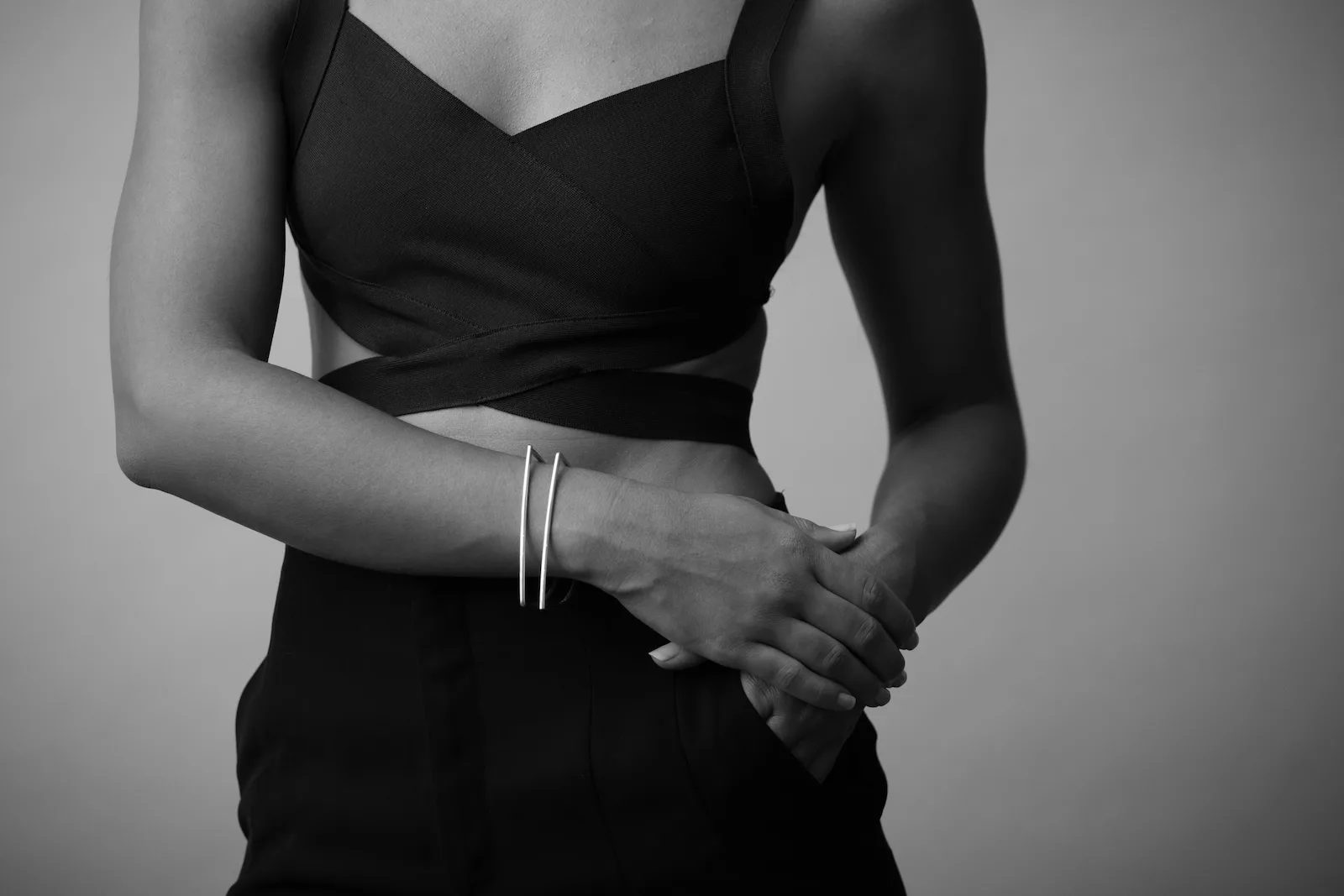 Arm across body wearing two silver bracelets