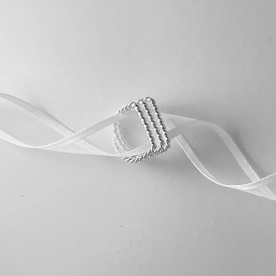 Sterling silver ring encircling a white lace ribbon