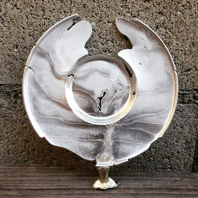 Cast pewter plate resting on a bench outdoors