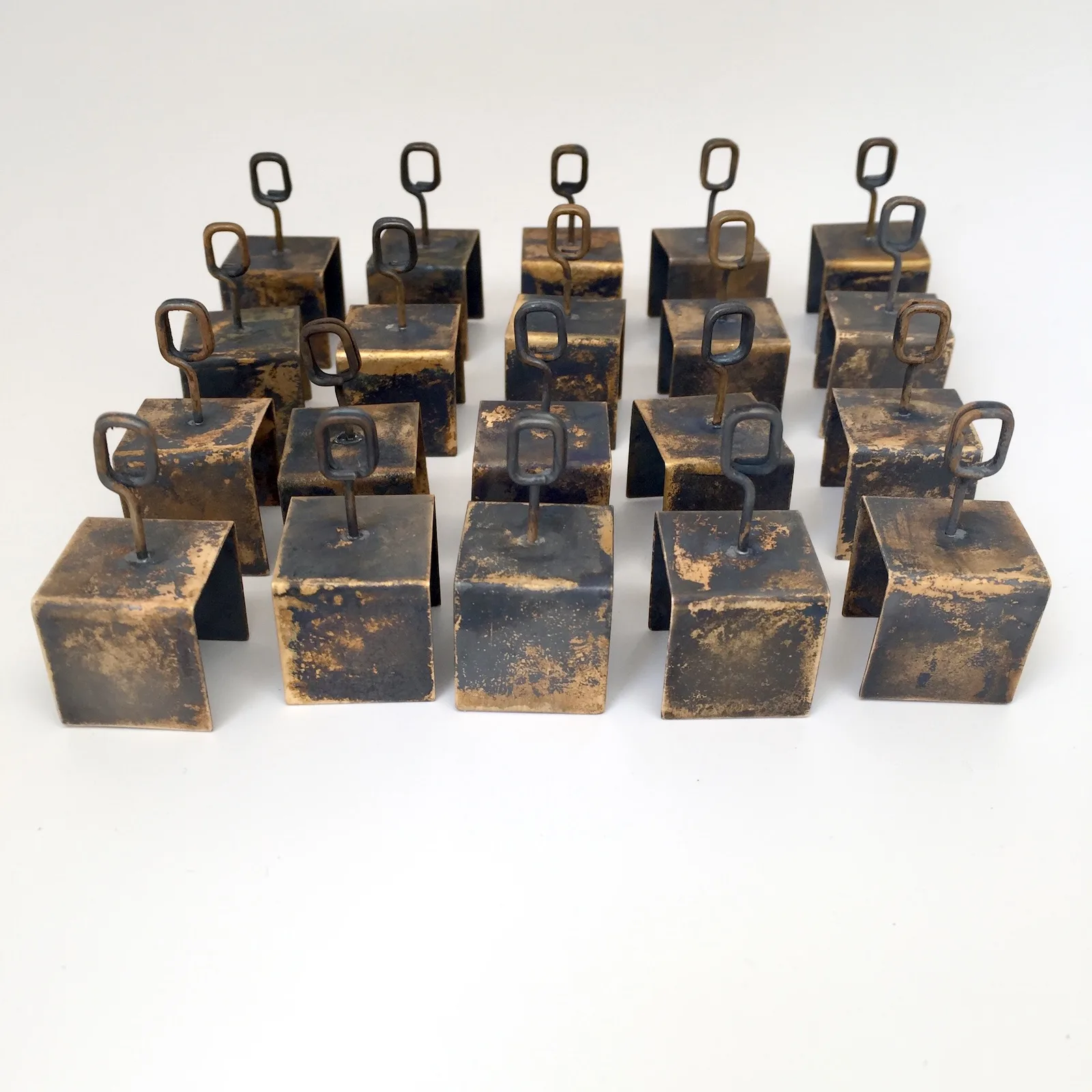 Small patinated brass objects used in a bakery to display item names