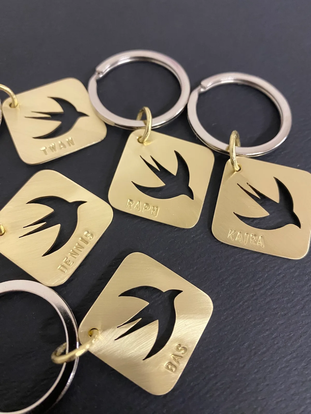 Set of brass keychains with a Swift bird silhouette cutout