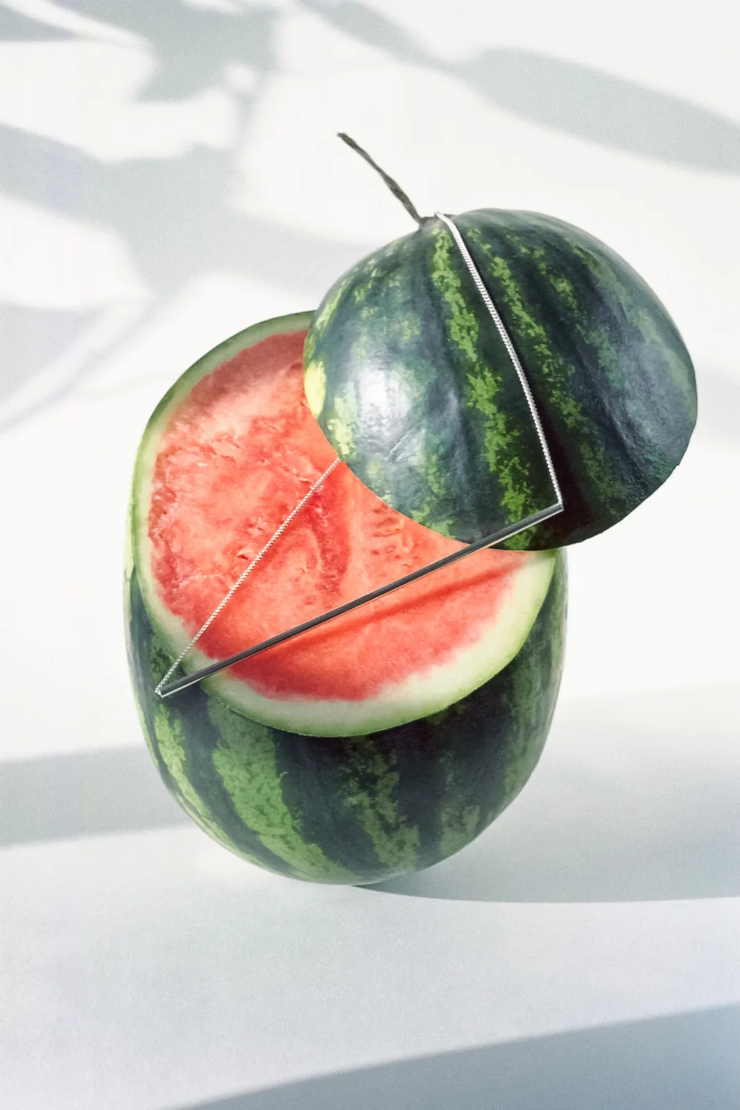 Halved watermelon with a silver necklace placed across the cut surface