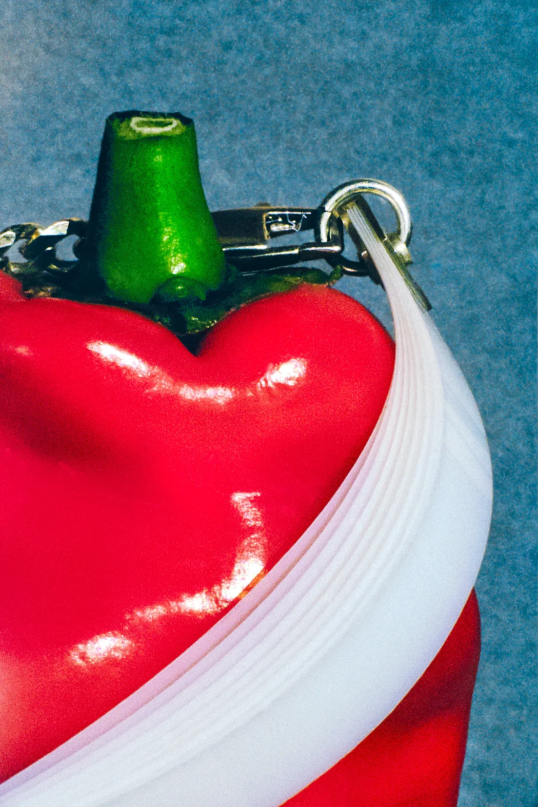 White Mylar sculptural bracelet wrapped around a red pepper